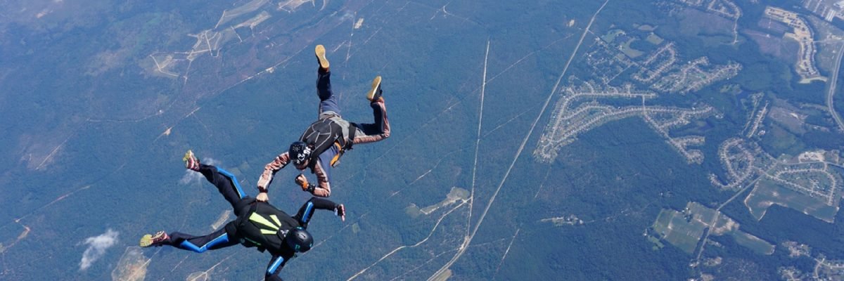 learn to skydive student flies receives hands-on attention from instructor in freefall