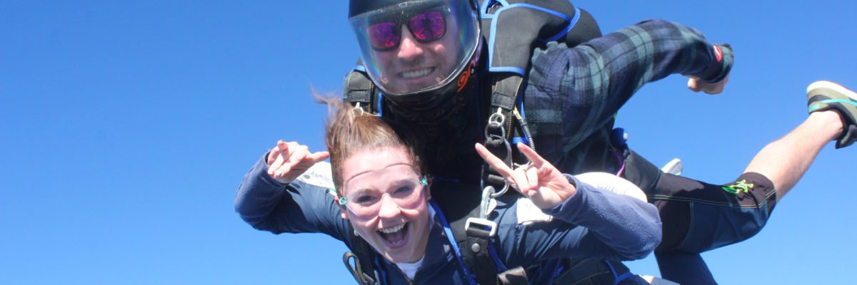 Tandem skydivers in freefall smiling