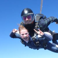 Tandem skydivers in freefall smiling