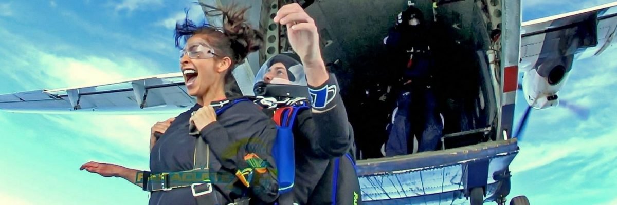 exit shot of woman tandem skydiving near Fayetteville