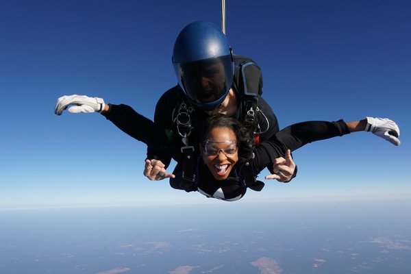 woman smiles ear to ear tandem skydiving first time