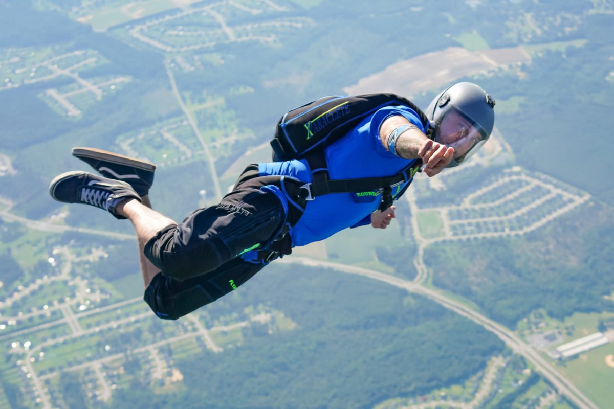 Licensed jumper wearing a tee shirt and swoop shorts points at the camera. 