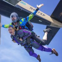 Tandem skydivers exit airplane