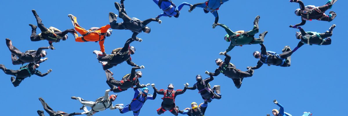 A group of skydivers fly in the air