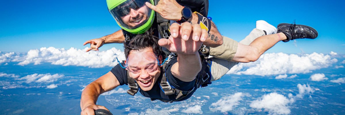 tandem skydiver grabs videographer foot in freefall