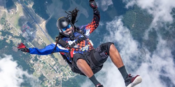 skydiver enters into freefall on his back and smiles big for the camera