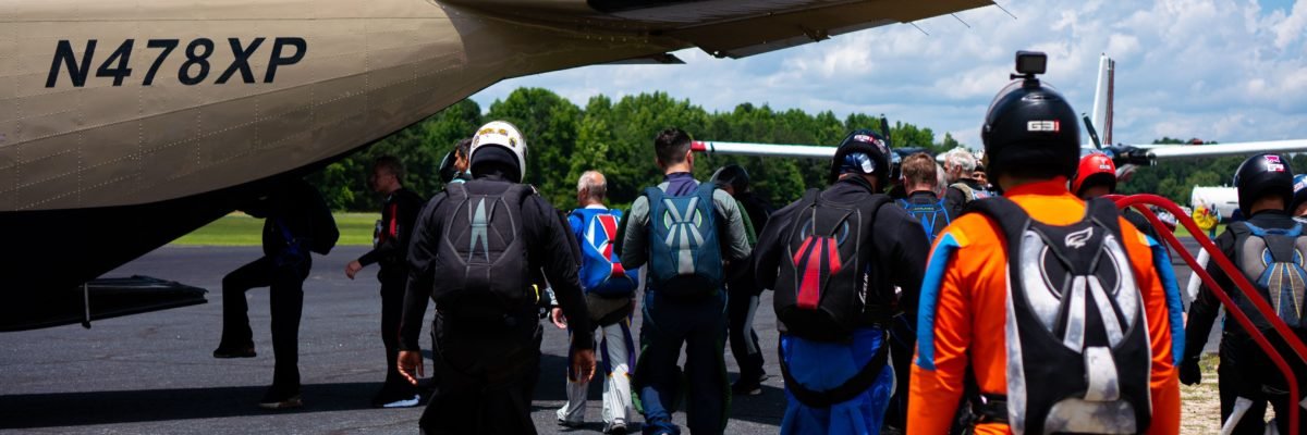 skydivers enter a jump plane through the tailgate