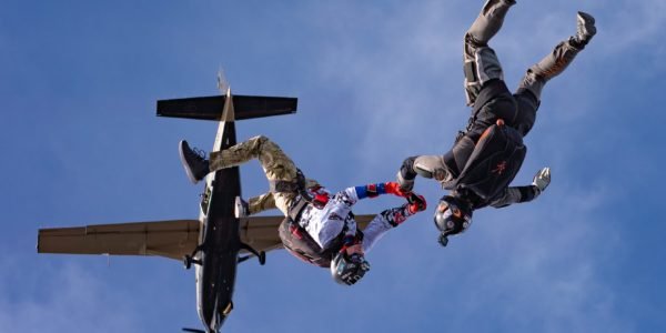 two skydivers exit plane in head-down orientation