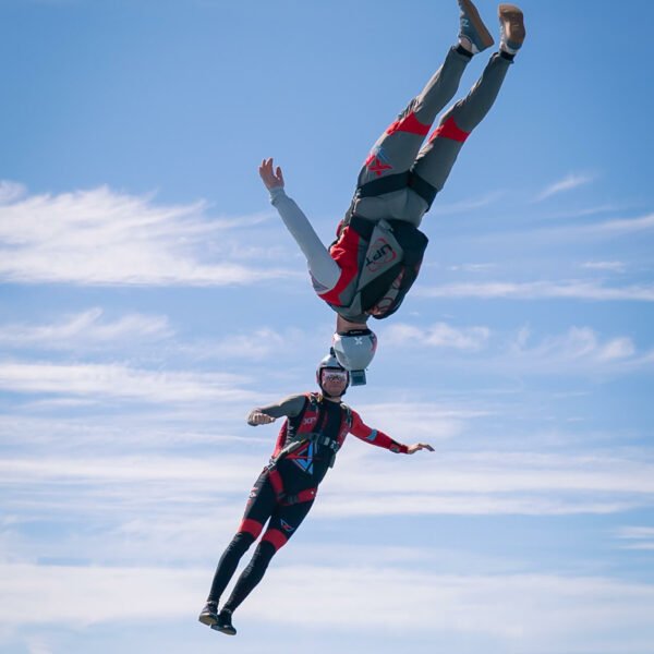 Two skydivers completing a freestyle routine in close proximity in the sky.
