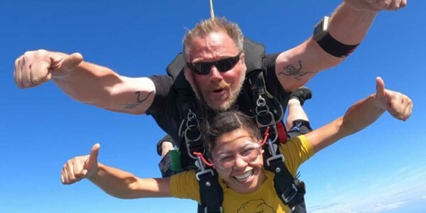 Tandem skydiver and her male tandem instructor during freefall